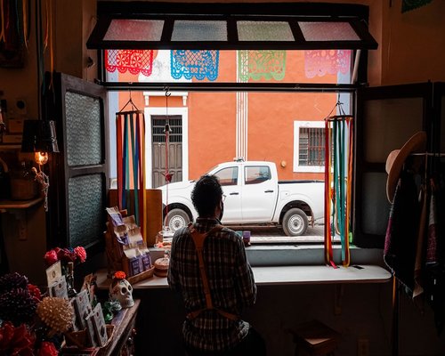 A professional working by a bright window in a Mexico City apartment, practicing comfortable lighting setup